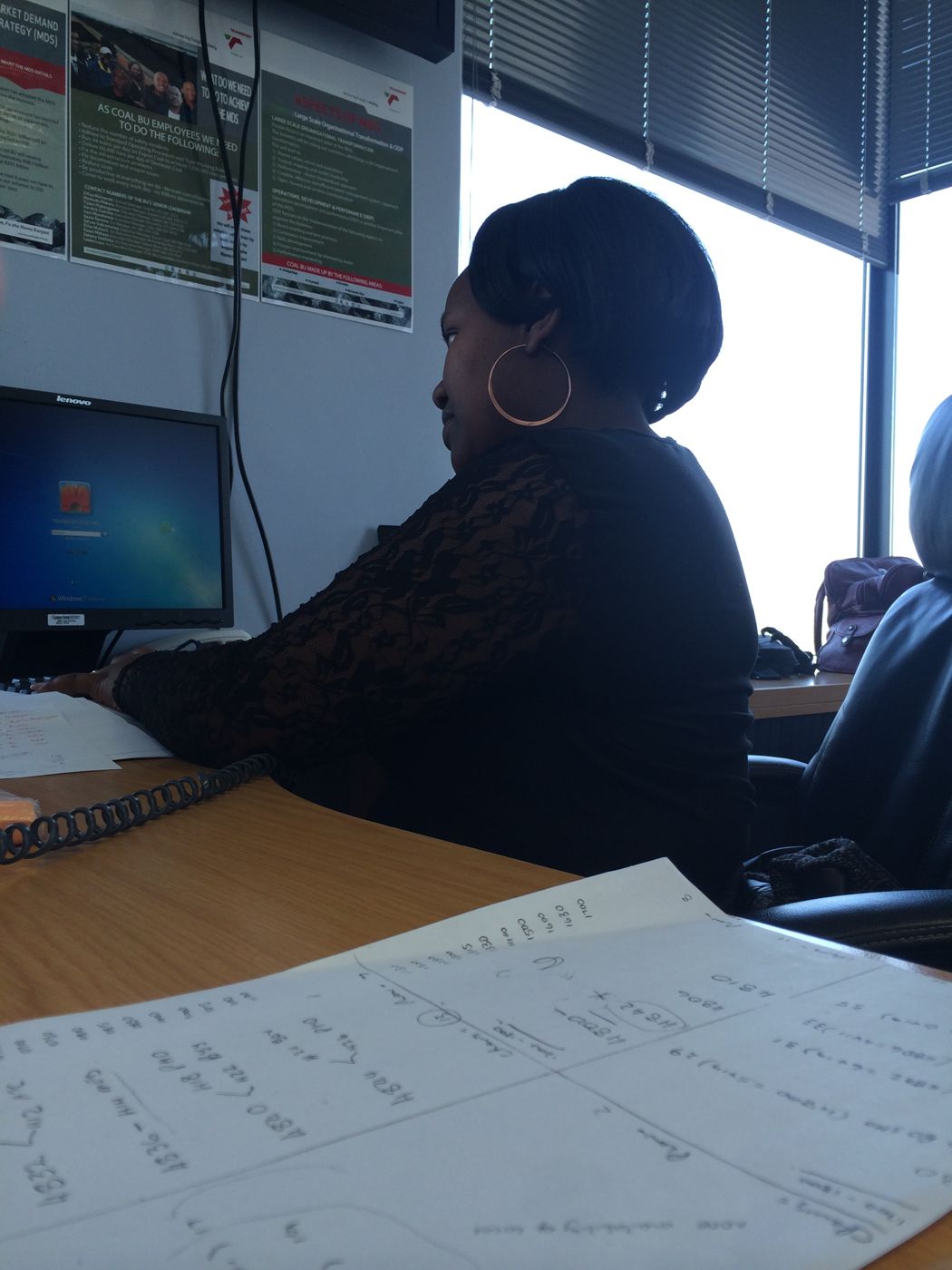 A control-point operator working from paper records at her desk.